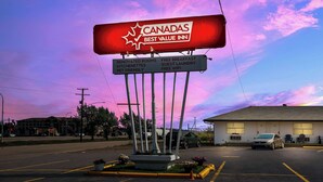 En skylt för hotellet Canadas Best Value Inn, där det anges vilka bekvämligheter som erbjuds, till exempel renoverade rum, pentry, möjlighet att ta med husdjur, gratis frukost, gästtvätt och gratis Wi-Fi.