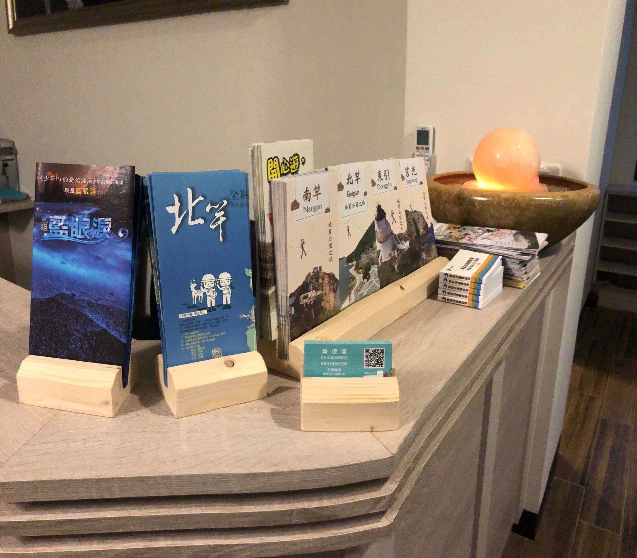 A display of books with wooden stands, a QR code, and a decorative item with a glowing light.
