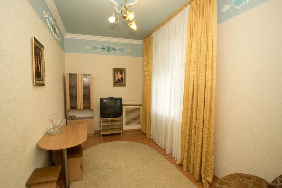 Habitación triple de lujo, vista al patio | Área de sala de estar | Televisión