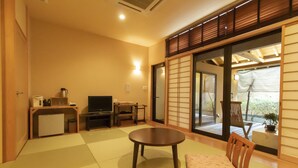 Ein traditioneller japanischer Wohnraum mit Tatami-Böden, einem niedrigen Tisch und Holzmöbeln.