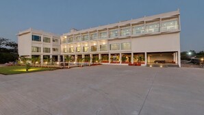 A modern multi-story hotel with a spacious courtyard, large windows, and outdoor seating areas. - Viola Beacon Resort Lonavala (Mawal)