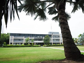 A building with a flat roof, multiple windows, and a central entrance. - Malhaar Resort (Dahegam)