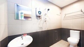 A bathroom with a white sink, a toilet, and a shower unit.