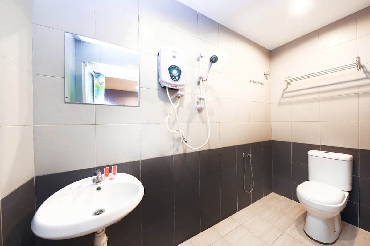 A bathroom with a white sink, a toilet, and a shower unit.