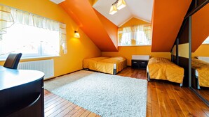 Een kamer met twee bedden, een bureau en een groot raam.