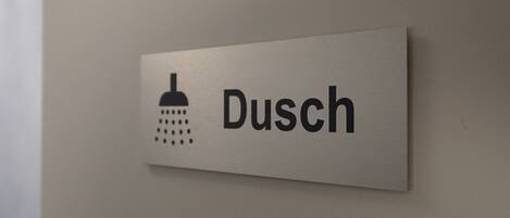 A sign with a shower icon and the word 'Dusch' indicating a shower area.