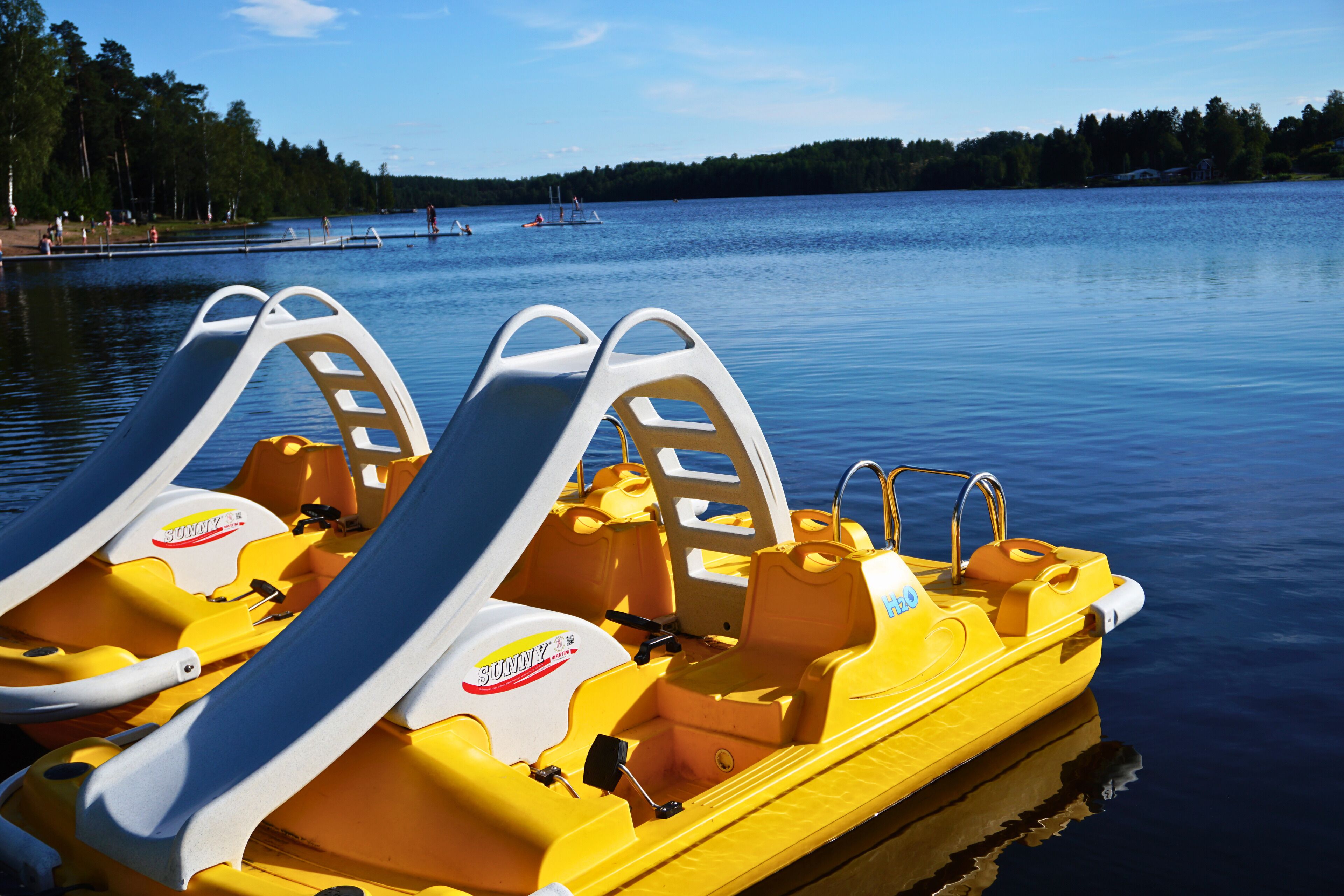 Un bateau jaune équipé de deux toboggans, d’un volant et orné du logo « SUNNY ».