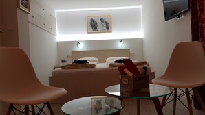 A bedroom with a bed, bedside tables, a TV, and a framed artwork above the bed. - Galeria Nura (Mostar)