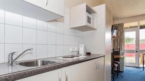 Een moderne keuken met witte kasten, roestvrijstalen apparatuur en een granieten aanrecht.