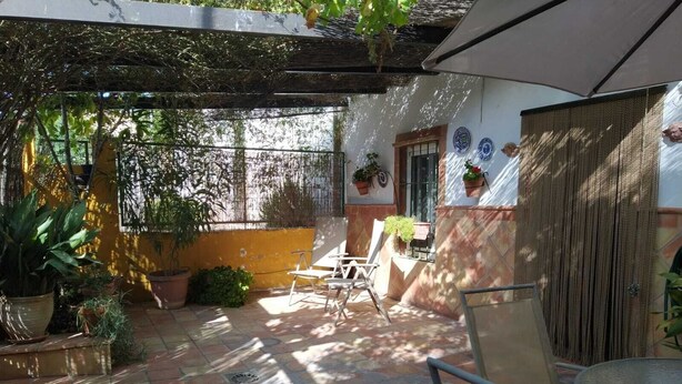 A patio with tiled flooring, outdoor furniture, and potted plants. - Magina Dream Pegalajar (Pegalajar)