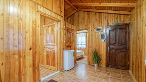 A wooden cabin interior with a bed, a refrigerator, and a door labeled "EXIT". - Cuhadar Ahsap Evleri (Datça)