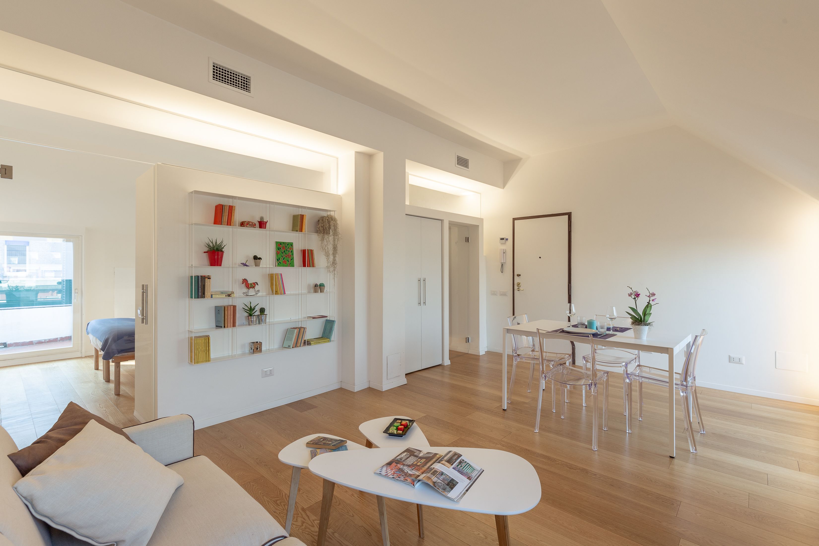 Een moderne woonkamer met een bank, salontafel en een eethoek met stoelen en een tafel.