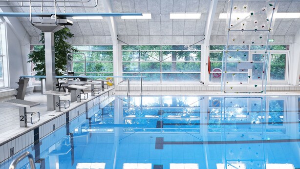 A large indoor swimming pool with clear lanes, a diving platform, and a climbing wall. - Tønder Byferie (Tonder)