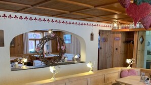 A cozy restaurant with wooden interiors, a central counter, and heart-shaped decorations.