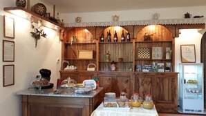 A kitchen with wooden cabinetry, a refrigerator, and various kitchen items on the counter. - Agriturismo Persichitti (Torricella Peligna)
