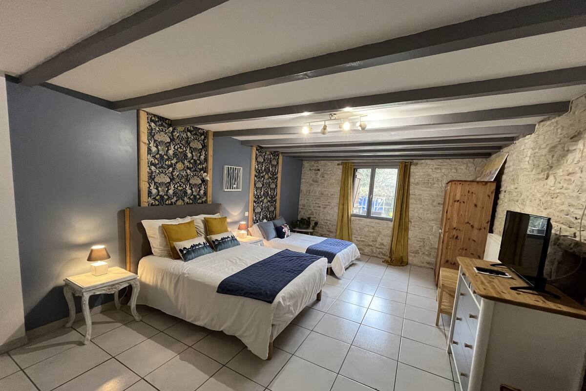 Een slaapkamer met twee bedden, een bureau en een televisie.