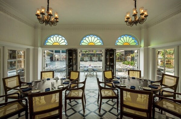 Un comedor con vistas a la calle, que incluye una mesa grande con sillas y candelabros.