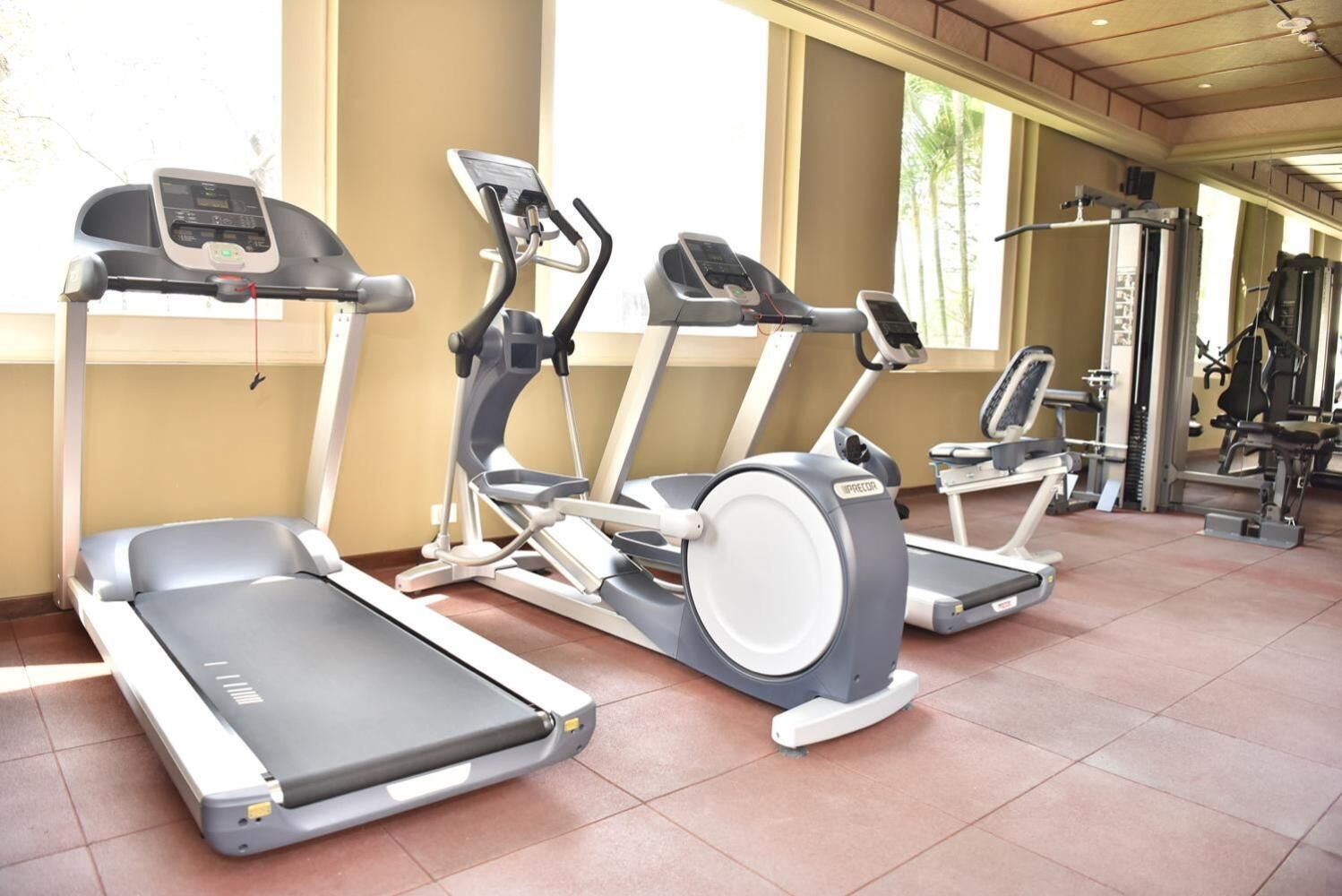 Een sportschool met loopbanden, elliptische trainers en gewichten.