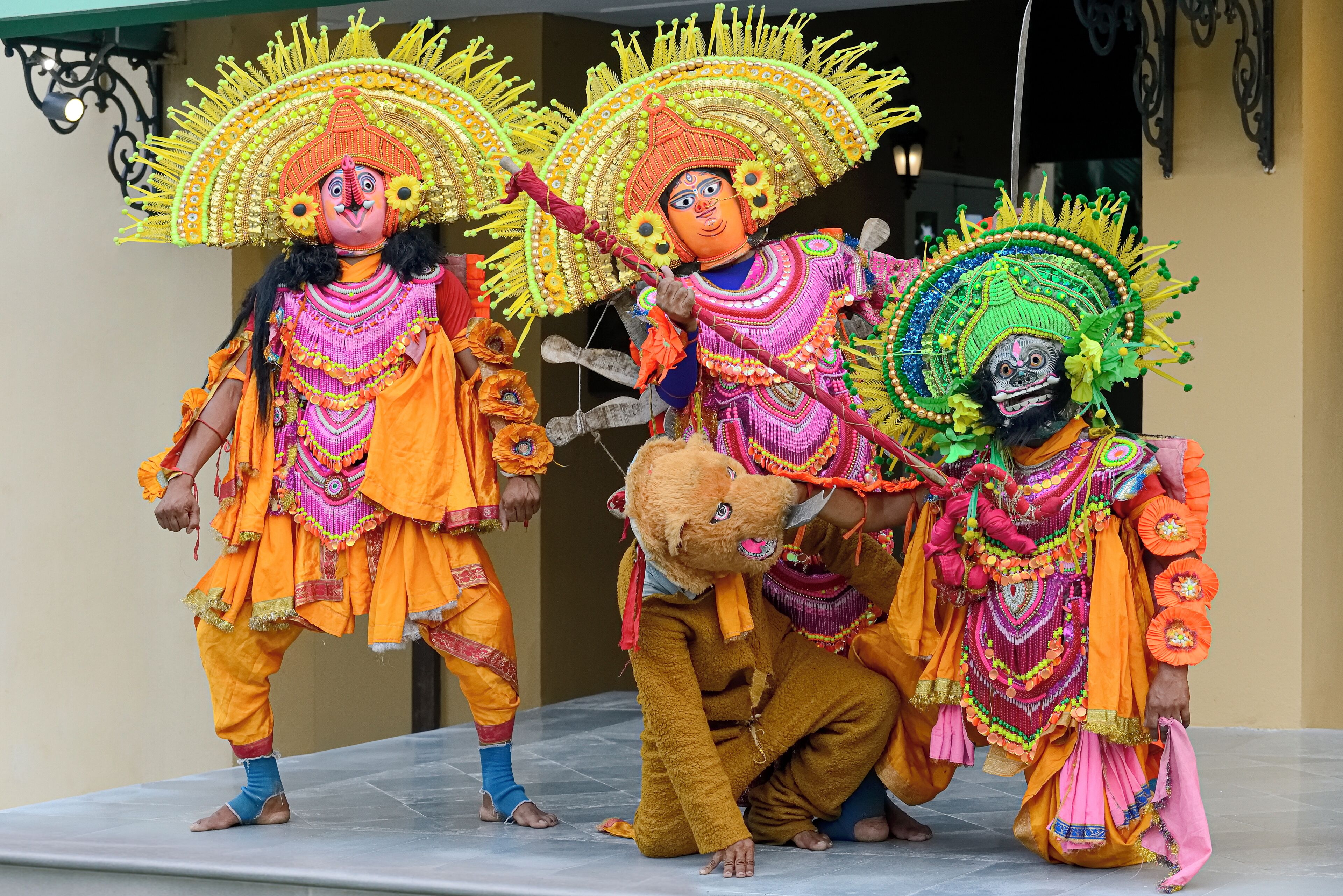 A group of performers in traditional costumes with elaborate headdresses.