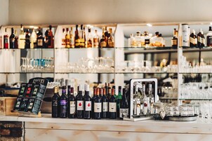 Zona de bar con varias botellas de licor y vasos.