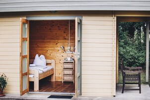 Una cabaña acogedora de madera con cama, una mesita y un banco.