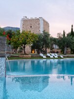 Una piscina al aire libre, sombrillas, sillones reclinables de piscina