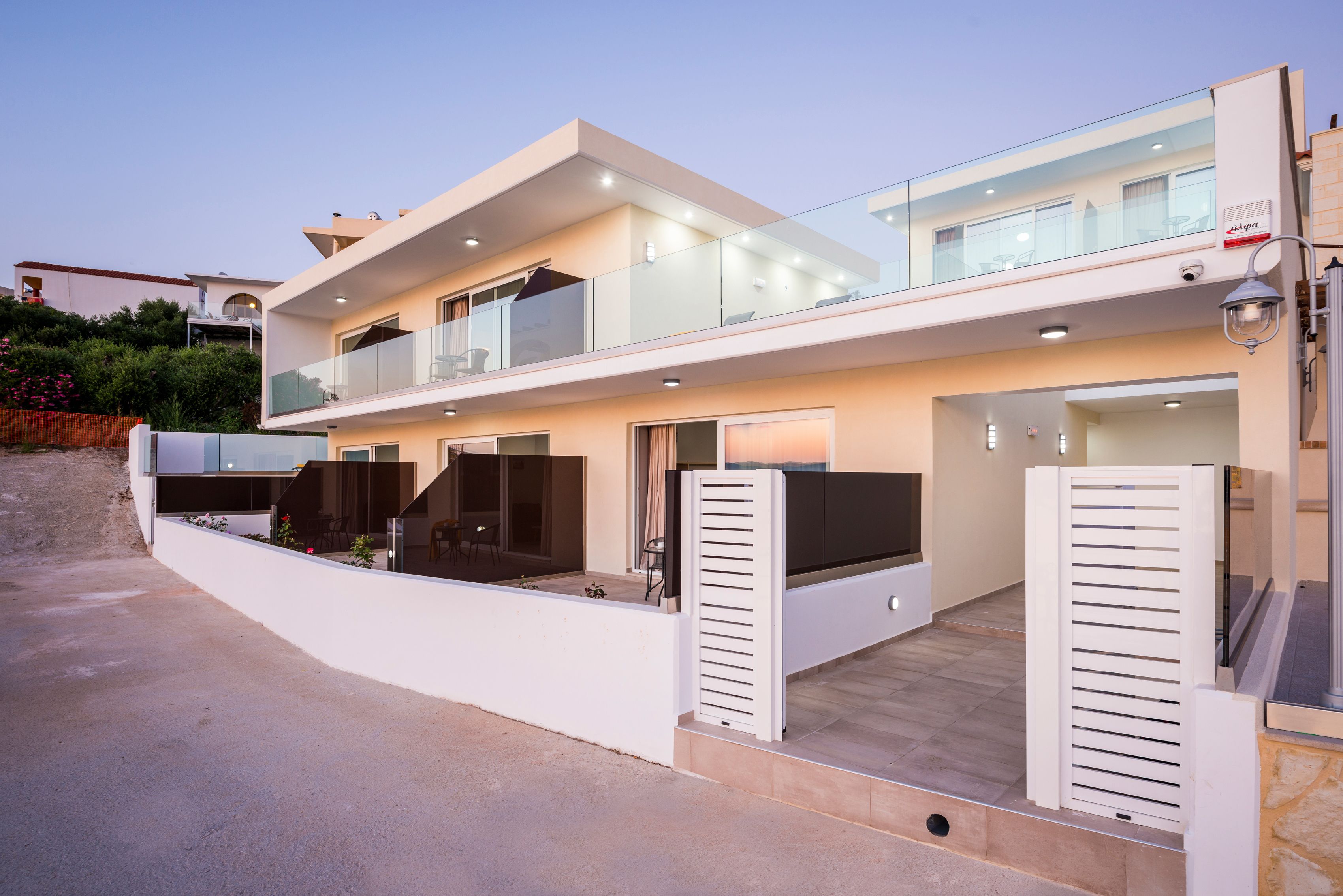 Ein modernes, zweistöckiges Haus mit Balkon, Garage und einer gut beleuchteten Eingangsparte.