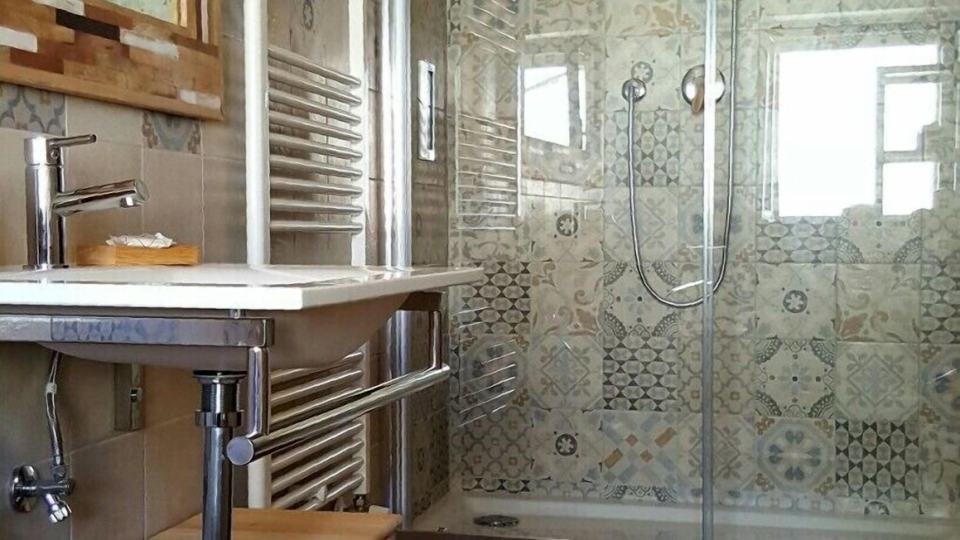 A bathroom with a shower, a sink, and a toilet.