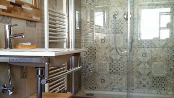 A bathroom with a shower, a sink, and a toilet.