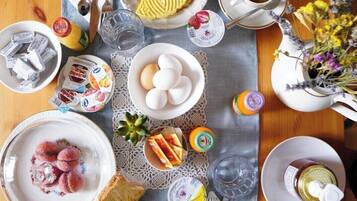A breakfast table with various food items, utensils, and a cup of coffee.