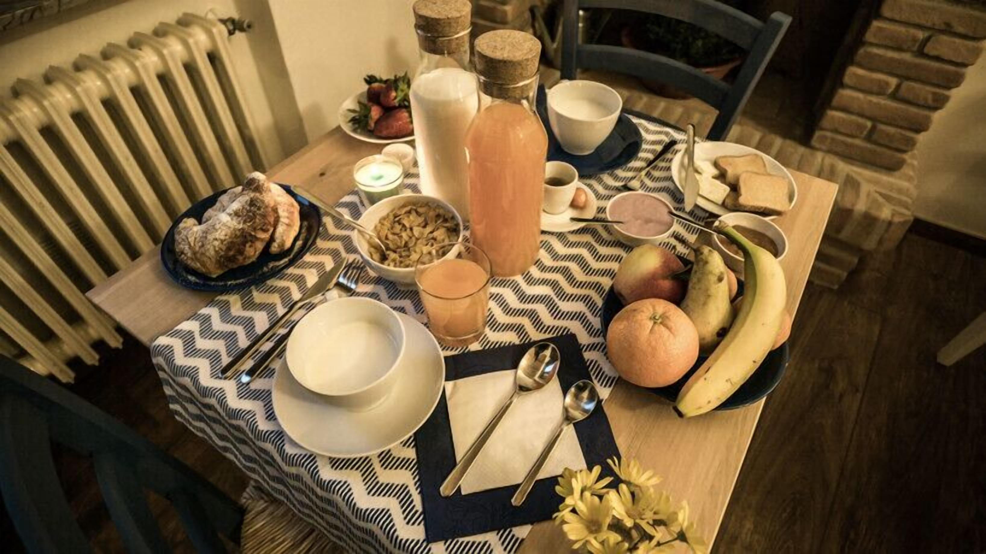 Une table à manger avec divers plats et ustensiles, un radiateur et un mur de briques en arrière-plan.