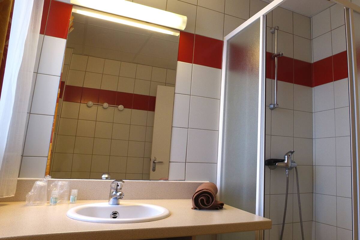 Ein Badezimmer mit Waschbecken, Spiegel und Dusche.