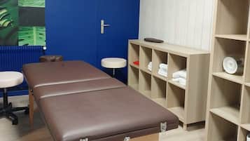Relax in this serene space with a massage table, comfortable chair, and ample storage.