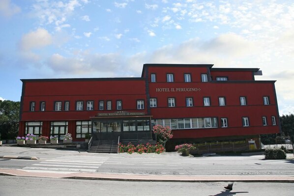 A red building with the signs "HOTEL IL PERUGINO" and "HOTEL RISTORANTE IL PERUGINO". - Hotel Il Perugino (Corciano)