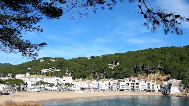 A coastal town with white buildings, a sandy beach, and a rocky shoreline. - Casas Golf Relax (Pals)