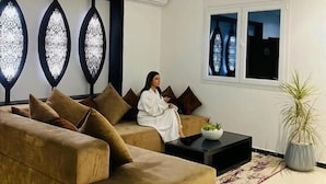 Un salon moderne avec un grand canapé, un plafond décoré de vitraux et une plante en pot.