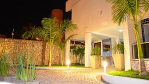 A building with a stone facade, a tiled entrance, and potted plants. - Happy Hotel Ponta Negra (Natal)