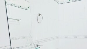 A bathroom with a white sink, toilet, and a glass shelf. - Shell Hotel Condao (Ho Chi Minh City)