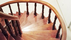 A wooden spiral staircase with a handrail and wooden balusters. - Shell Hotel Condao (Ho Chi Minh City)