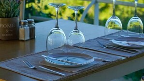 A table set for dining with a view of the sea and greenery. - Almiros Apartments (Corfu)