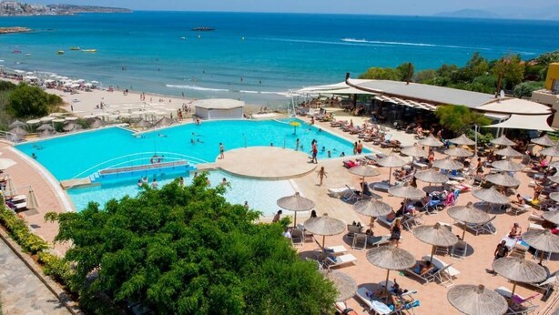 A resort with a large pool, beach area, and umbrellas. - Almiros Apartments (Corfu)