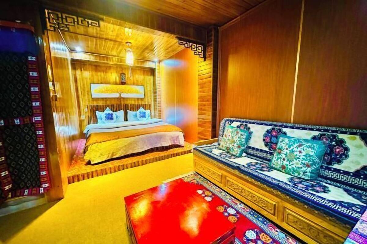 A room with a bed, a sofa, and a red table.