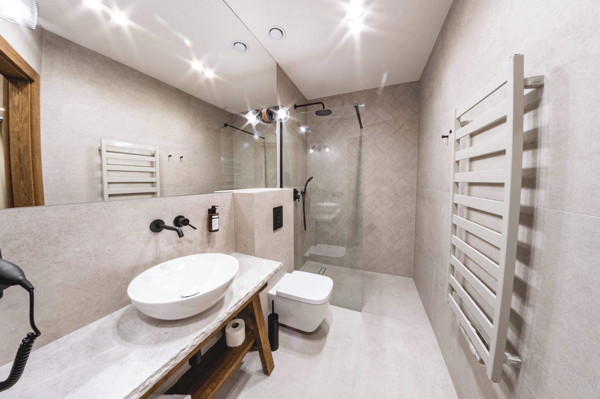 A modern bathroom with a large sink, toilet, and walk-in shower.
