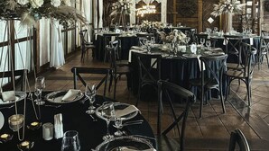A restaurant with round tables set for dining, featuring black tablecloths and silverware. - Dwór Bogucin Hotel & Restauracja (Garbow)