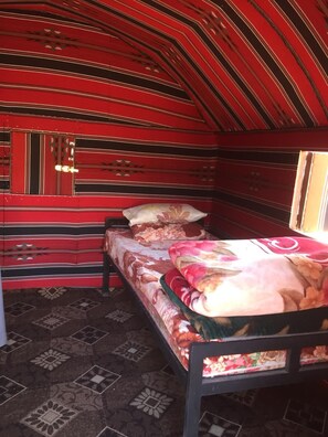 A room with a bed, a window, and a patterned wall.