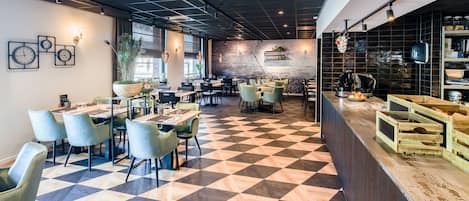 Un restaurant moderne avec un sol à carreaux, de nombreuses tables et des chaises.