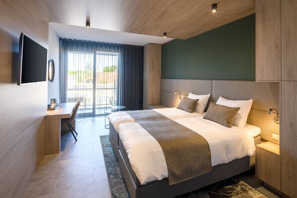 A modern hotel room with a large bed, a desk, and a TV. - Hotel 46 (Wintelre)