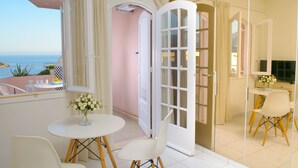 Ein modernes Hotelzimmer mit Balkon, Essbereich und Küchenzeile.