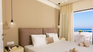 Ein Hotelzimmer mit einem großen Bett, einem Nachttisch und Meerblick.
