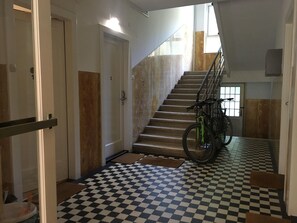 A staircase with a checkered floor, a bicycle, and a door marked with the number 3. - Fingerprint Tree Apartment (Zagreb)